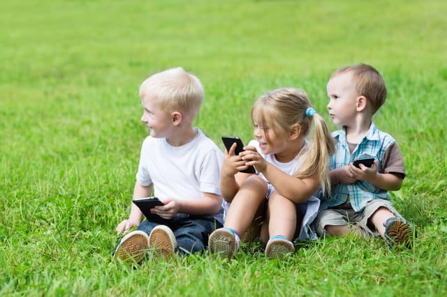 Kinder spielen mit Smartphones im Freien Kita Rostock
